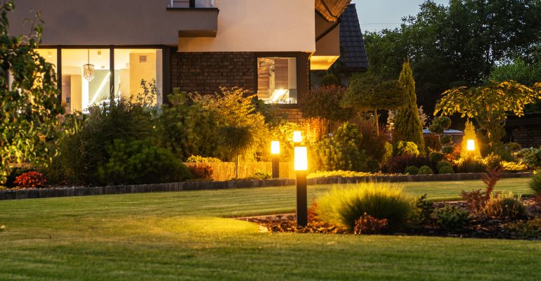 a nice looking house with a garden and illuminating garden lights