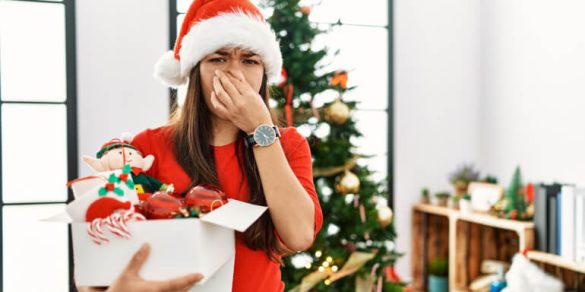 Woman holding her nose because of smelly Christmas tree