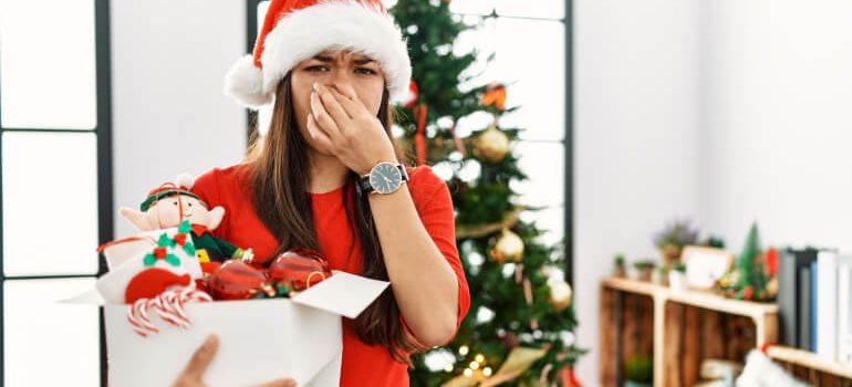 Woman holding her nose because of smelly Christmas tree