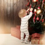Toddler decorating a Christmas tree