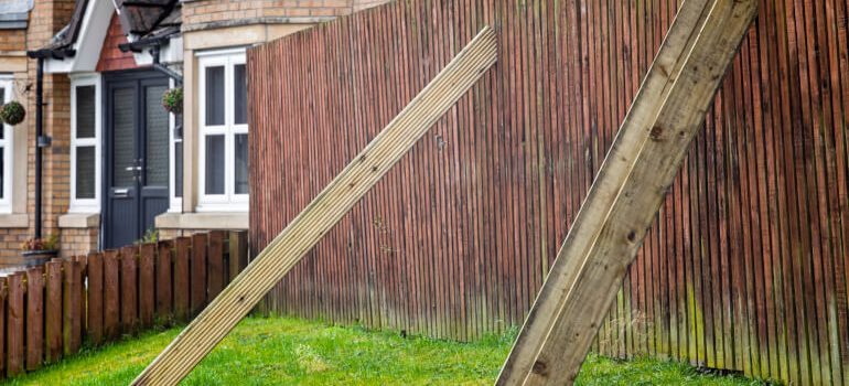 Temporary fix of a damaged wooden fence with wooden props