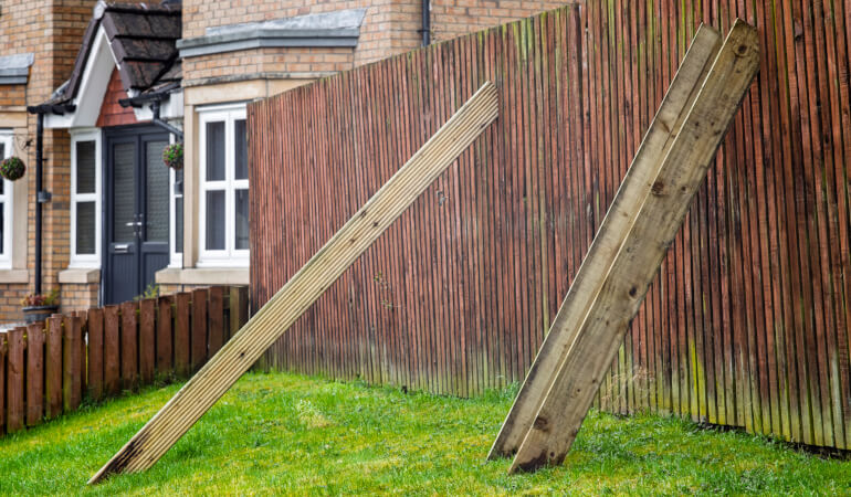 Temporary fix of a damaged wooden fence with wooden props